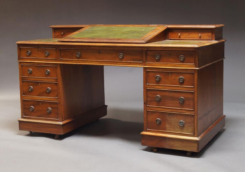An Edwardian mahogany pedestal desk, the top inset with green leatherette, having hinged writing slope enclosing storage space and flanked by two drawers, over an arrangement of eight drawers, raised on castors, 87cm high, 151cm wide, 77cm deep