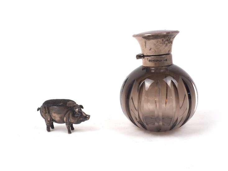 An Edwardian novelty silver pig pin cushion, Chester, 1908, Adie & Lovekin, realistically modelled in standing position with raised pin cushion to back, 5.4cm long, 3.2cm high, together with a silver mounted purple glass vanity jar with mauve...