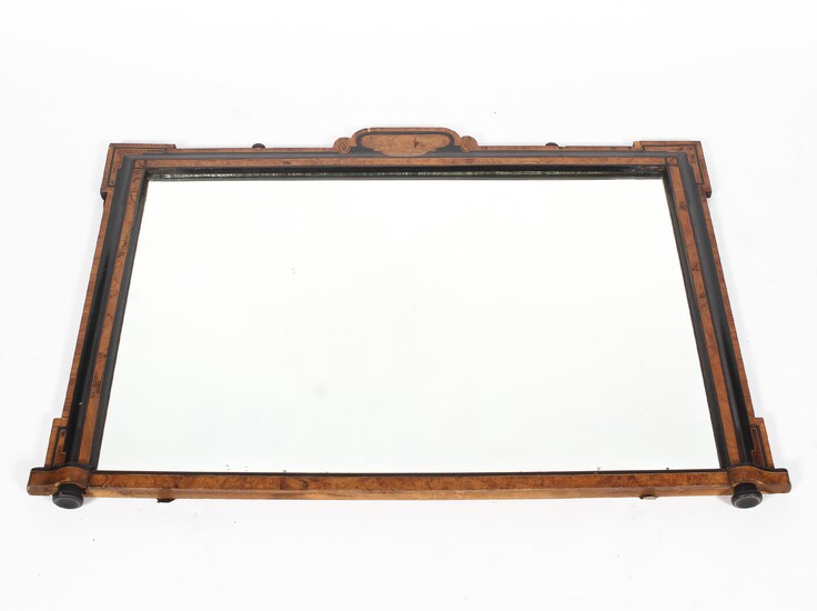 An antique veneered rectangular overmantle mirror, the shaped frame with inlaid details