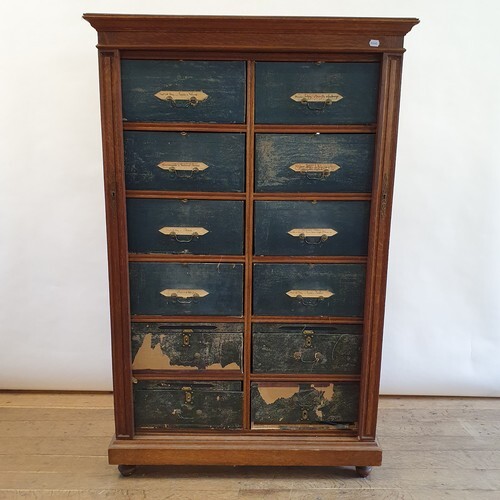 An early 20th century oak cartonnier, with twelve painted ca...