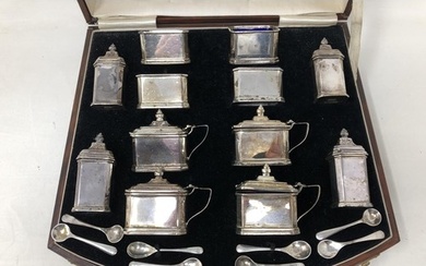 An extensive George V silver cruet set, comprising four pepp...