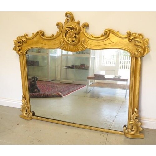 An ornate gilt over mantle mirror, 130cm tall x 152cm wide, ...