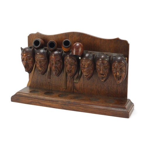 Carved oak devil head design pipe stand with four pipes incl...