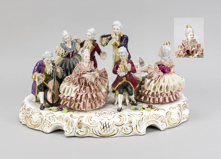 Large group of musicians in Rococo style, Kronach, Upper Franconia, 20th c., elegant lady on the spinet, accompanied by flute a. cello players, two ladies a. a cavalier singing, on oval rocaille base with sculptural flowers, tulle dresses, flute a...