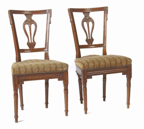 Pair of Louis XVI chairs end of 18th century, beech, round legs and frame with fluted trains, backrest with lyre-like bracing and carved rosettes and leaf motifs, shield-shaped seat, erg. Upholstery cover with tapestry embroidery in tendril pattern...