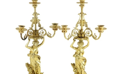 Une paire de candélabres français en bronze doré à quatre lumièresavec des branches feuillagées défilantes...