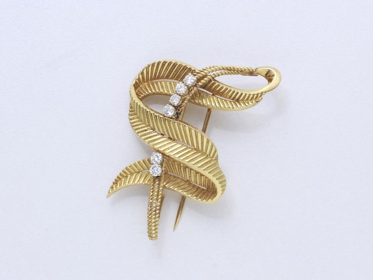 750-thousandths gold clip brooch, stylizing a leaf coiled...