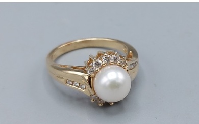 A 14ct gold ring set solitaire pearl surrounded by Diamonds ...