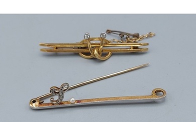 A 15ct gold bar brooch set with a diamond encrusted L and a ...