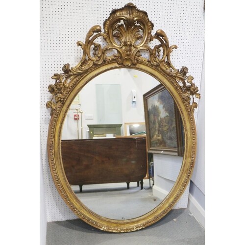 A 19th century gilt framed oval wall mirror with Rococo scro...