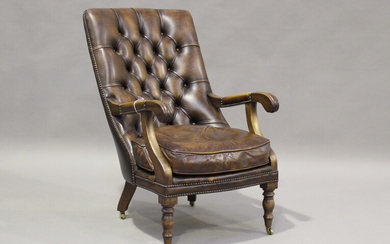 A 20th century Victorian style buttoned brown leather library armchair, raised on turned legs and ca