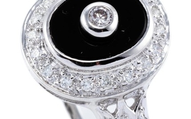 A DECO STYLE 9CT WHITE GOLD ONYX AND DIAMOND RING; oval onyx plaque centre set with a round brilliant cut diamond, to surround and s...