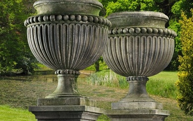 A PAIR OF LARGE AND IMPRESSIVE CARVED LIMESTONE GARDEN URNS ON PLINTHS IN IMPERIO TASTE, LATE 20TH