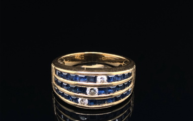 A SAPPHIRE AND DIAMOND THREE ROW CHANNEL SET HALF HOOP RING. UNHALLMARKED, ASSESSED AS 18ct GOLD.