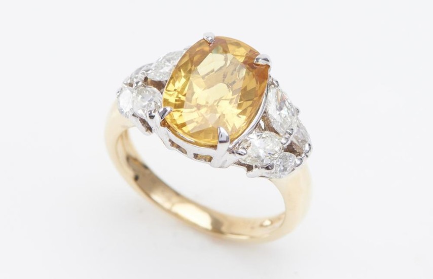 A YELLOW SAPPHIRE AND DIAMOND RING-The oval cut yellow sapphire weighing 5.02cts, shouldered by marquise cut diamonds totalling 0.90...