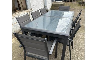 A contemporary grey metal garden table with two piece glass ...