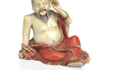 A gilt and lacquer decorated soapstone figure of a luohan