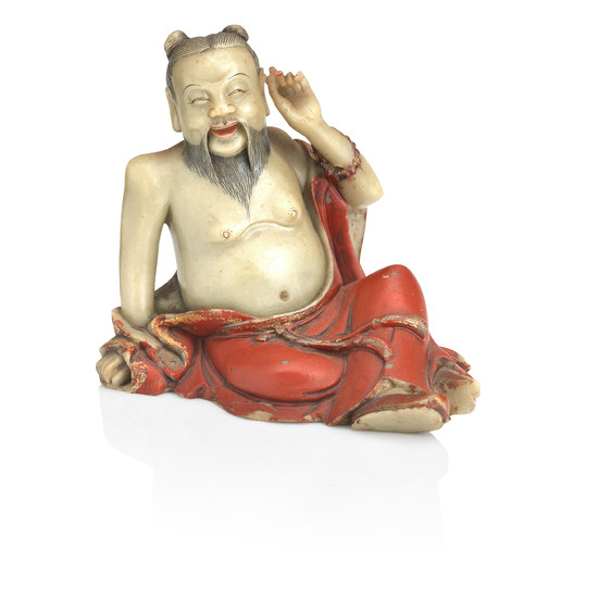 A gilt and lacquer decorated soapstone figure of a luohan
