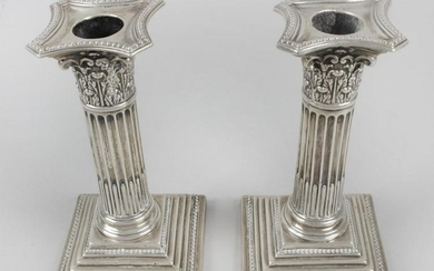 A pair of late Victorian silver mounted candlesticks