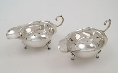 A pair of silver sauce boats, Birmingham, 1938, Grant & Son, with scroll handles on three shell capped hoof feet, 15.5cm wide, total weight approx. 6.1oz (2)
