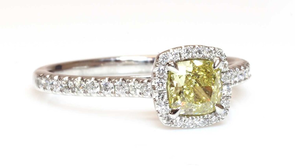 A platinum fancy yellow diamond and diamond halo cluster ring