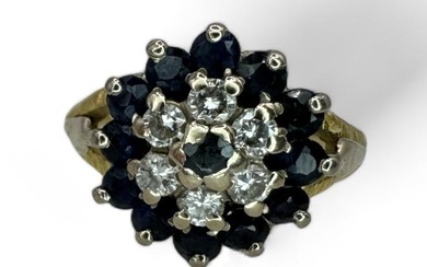 A sapphire and diamond target cluster ring. Set into yellow...