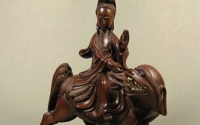 A well-carved wooden sculpture of Guanyin seated on a Buddhist lion, ca 1900-1920 - Tropical wood - China