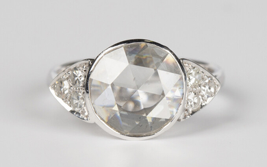 A white gold and diamond ring, collet set with the principal circular cut diamond between diamond se