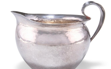 AN ARTS AND CRAFTS SPOT-HAMMERED SILVER JUG, unmarked