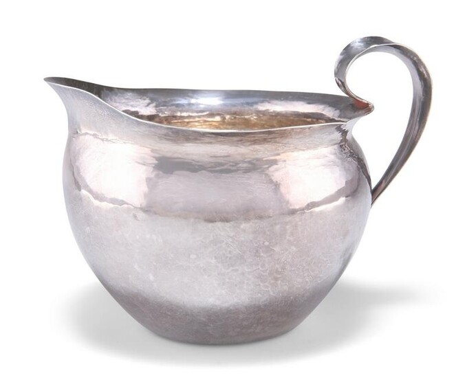 AN ARTS AND CRAFTS SPOT-HAMMERED SILVER JUG, unmarked