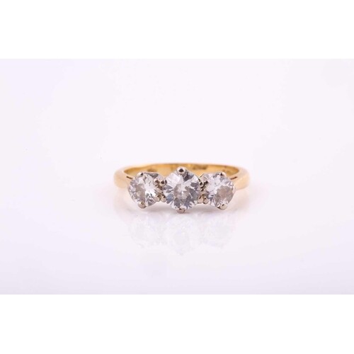 An 18ct yellow gold three stone diamond ring, set with a cen...