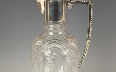 An Edwardian silver mounted glass claret jug, the clear glass ovoid body cut with arched panels and