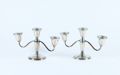 Coppia di piccoli candelabri a tre luci in argento, basi appesantite (g lordi 900) (cm 25x16) (difetti)