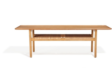 Hans J. Wegner: “AT 10”. A solid teak and oak coffee table with cane shelf. Manufactured by Andreas Tuck, Odense. H. 50. L. 160. W. 51 cm.