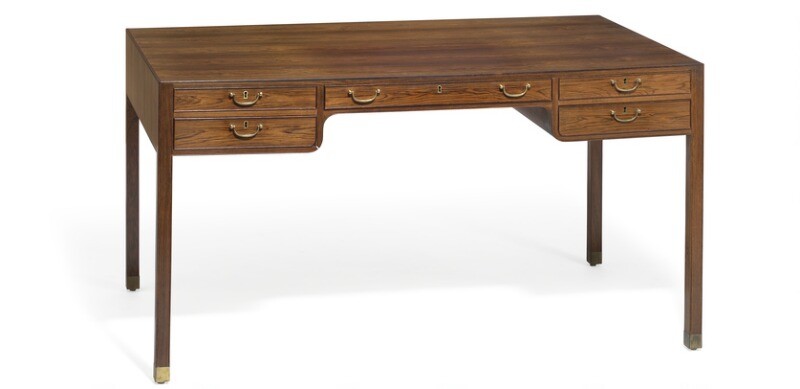 Jacob Kjær: Freestanding Brazilian rosewood desk with “shoes” of brass. Front with five profiled drawers with brass handles.