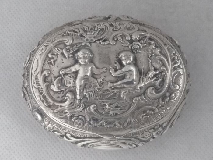Large oval box with playing puttis - .800 silver - J.D. Schleissner & Söhne - Germany - Late 19th century