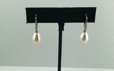 Pair of 750°/°°° white gold sleepers set with a line of diamonds holding a pear-shaped freshwater cultured pearl in pendants, Gross weight: 4,03g