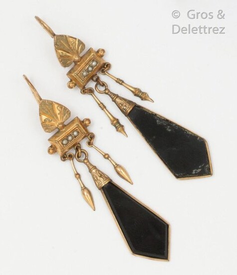 Pair of earrings in 9K yellow gold, decorated with palmettes and seed beads holding in pendants an onyx plate with two spinning tops. Swan neck clasp. Length: 6.5cm. Gross weight: 6.9g.
