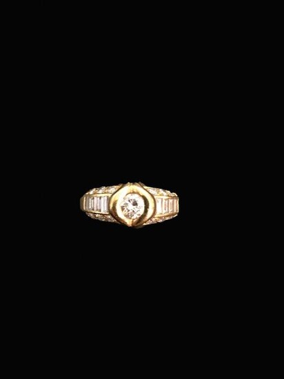 Ring in 18K (750°/°°) yellow gold set with a central brilliant-cut diamond surrounded by rows of baguette-cut diamonds between brilliant-cut diamonds.