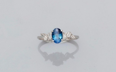 Ring in white gold, 750 MM, set with an oval sapphire weighing 1.05 carat and supported by two garlands of baguette-cut diamonds, 16 x 7 mm, size: 54, weight: 1.95gr. rough.
