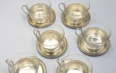 Six tasses à thé en verrerie avec cul et anse en métal argenté à décor...