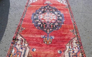 WASHED RED GROUND PERSIAN SAROUK RUG WITH A LARGE CENTRAL ME...