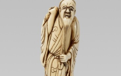 An ivory netsuke of a bearded sennin. Early 19th century