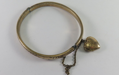 A GOLD-WITH-METAL-CORE BANGLE AND A GOLD-BACK-AND-FRONT HEART LOCKET