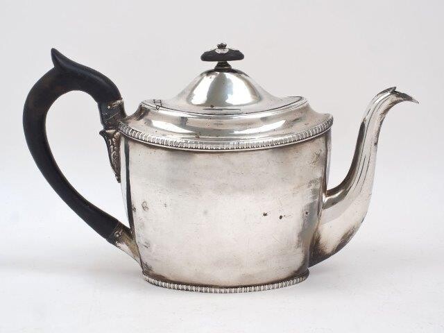 A George III silver teapot, London, 1802, Peter, Ann & William Bateman, of oval form with gadrooned banding to base and rim, the wooden finial with silver flowerhead decoration, 16.4cm high (inc. handle), approx. weight 17.6oz