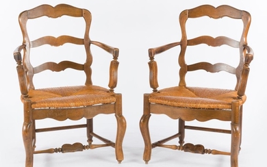 A PAIR OF FRENCH WALNUT LADDER BACK ELBOW CHAIRS WITH RUSHED SEATS ON STRETCHER BASES, 92CM H