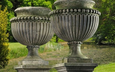 A PAIR OF LARGE AND IMPRESSIVE CARVED LIMESTONE GARDEN URNS ON PLINTHS IN IMPERIO TASTE, LATE 20TH