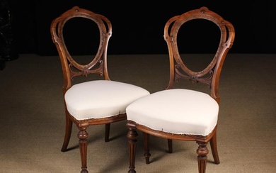 A Pair of Victorian Carved Walnut Medallion-back Chairs. The oval back frames, once with upholstered