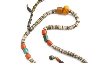 A Tibetan Tantric mala of bone discs, coral, amber and turquoise beads, with a large ivory bead carved in the form of a skull. C. 1900. L. c. 48 cm.