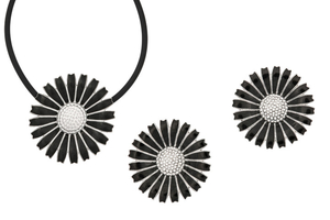 A black enamel ‘Daisy’ pendant and earclips, by...